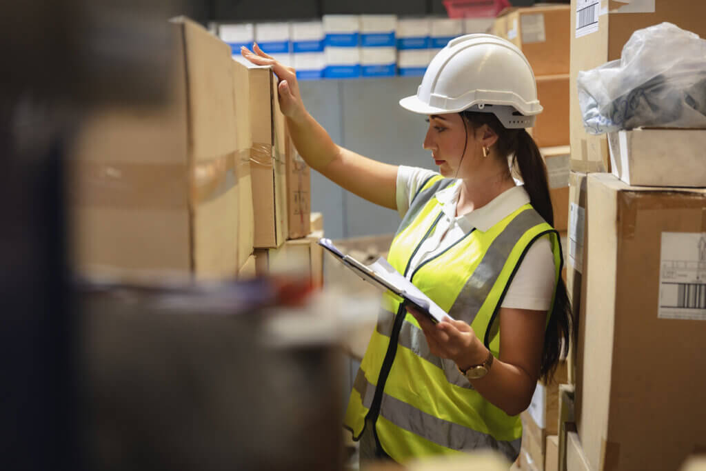 warehouse staff woman worker work intend checking products inventory stock carefully.